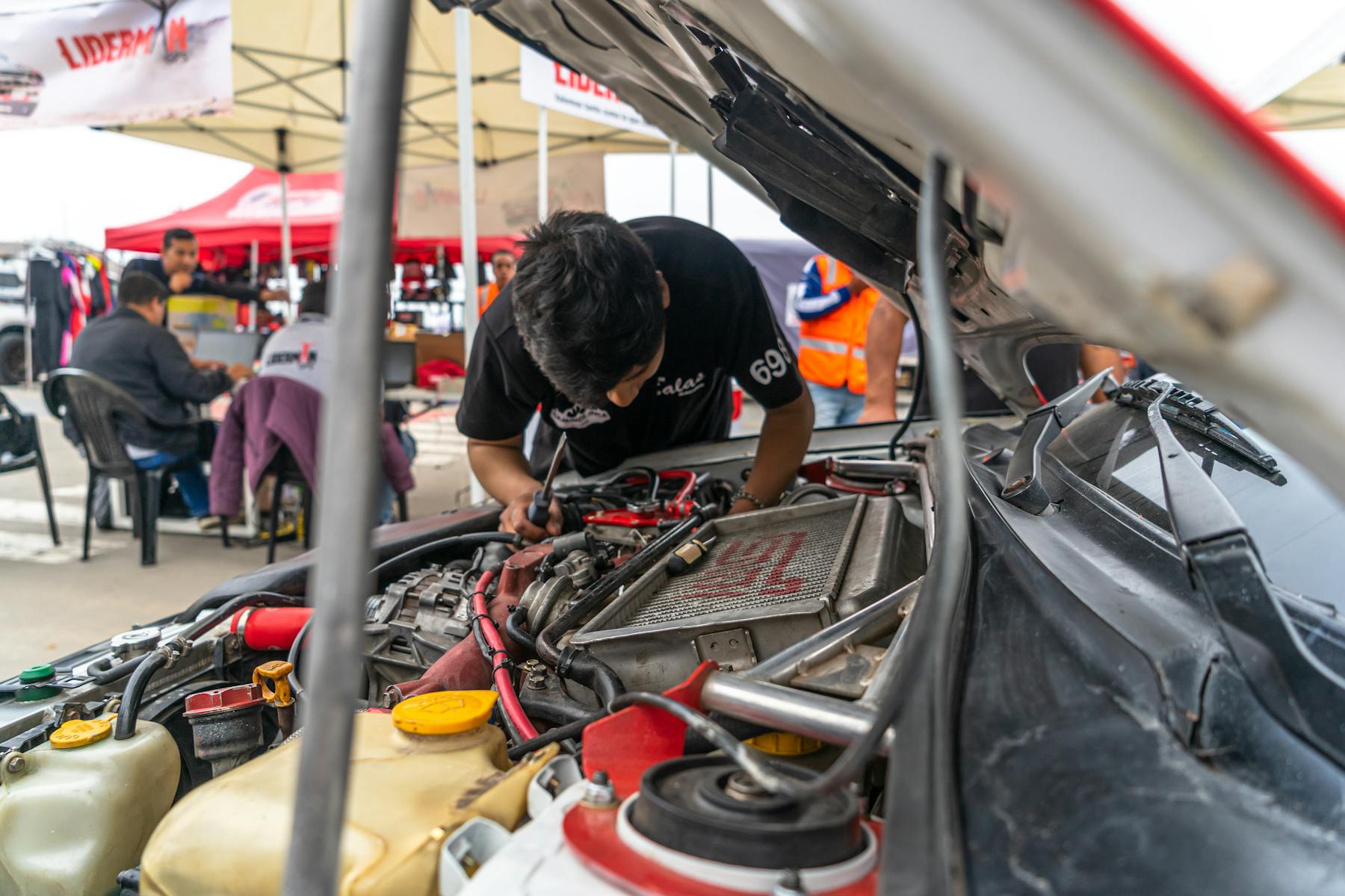 Mechanic working under the open hood of a car